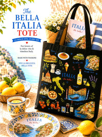 Black tote bag with Italian-themed illustrations on a table with lemons and a cup.
