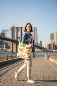 Brooklyn-themed products including a tote bag, mug, candy, and keychain on a wooden surface.