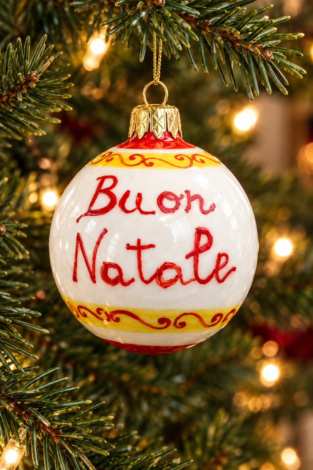 Buon Natale ornament hanging on a Christmas tree with warm glowing lights