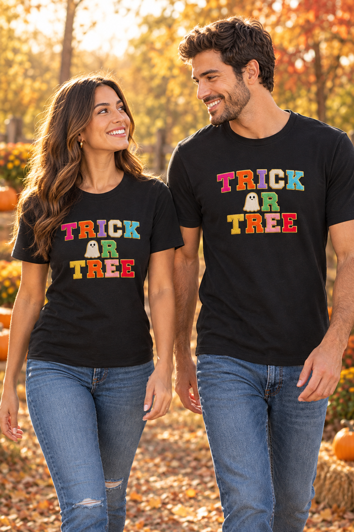 Couple walking in black Trick or Tree T-shirts in an autumn setting