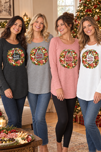Four women wearing the black, gray, pink, and white Buon Natale Antipasto tunics in a cozy Christmas setting