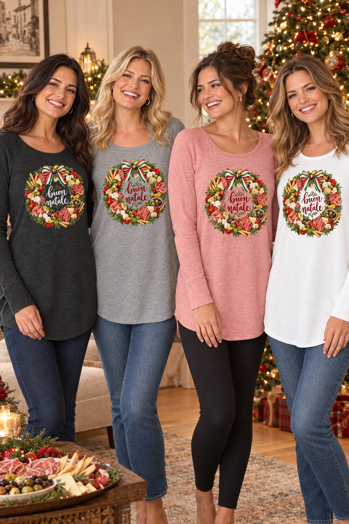 Four women wearing the black, gray, pink, and white Buon Natale Antipasto tunics in a cozy Christmas setting