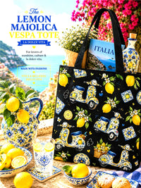 Black Lemon Maiolica Vespa tote bag with Italian-themed decor on a table with lemons and a magazine.