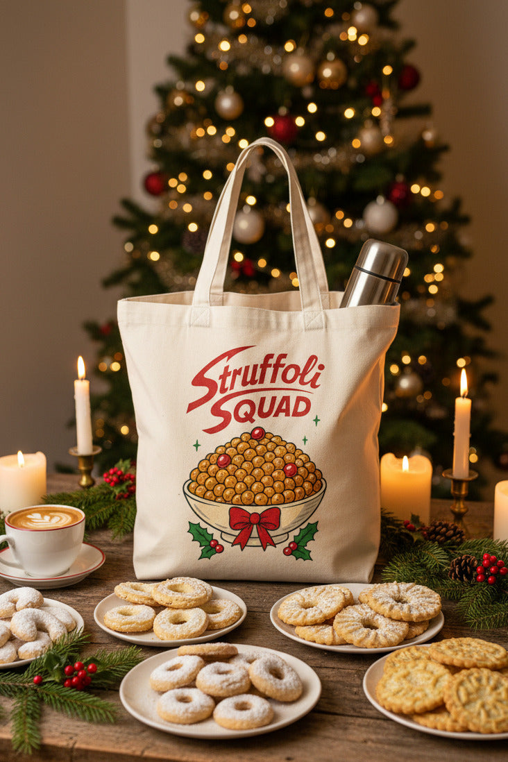 A cream canvas tote bag printed with 'Struffoli Squad' in red script and an illustration of stuffed pasta in a bowl, styled with a thermos, book, and plants on a table. The bag is surrounded by coffee, pasta, and holiday decorations, with Italian text overlays on the left.