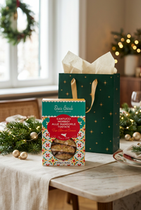 Tumminello soft almond cantucci box with an emerald Christmas gift bag on a marble dining table