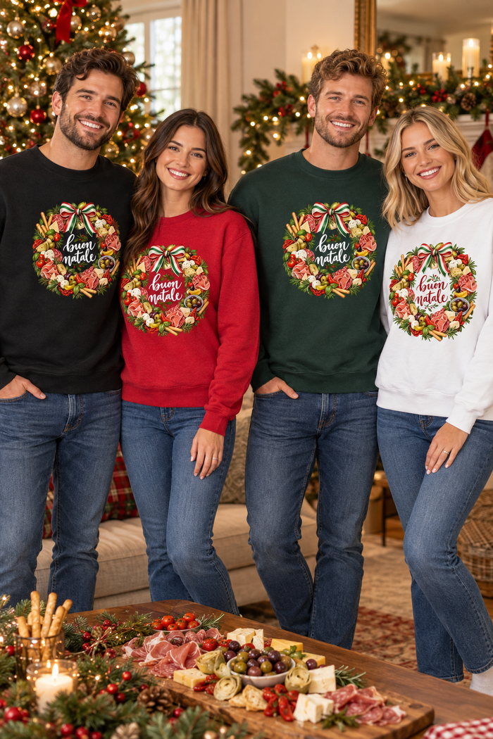 Two couples wearing black, red, green, and white Buon Natale Antipasto sweatshirts in a cozy Christmas setting