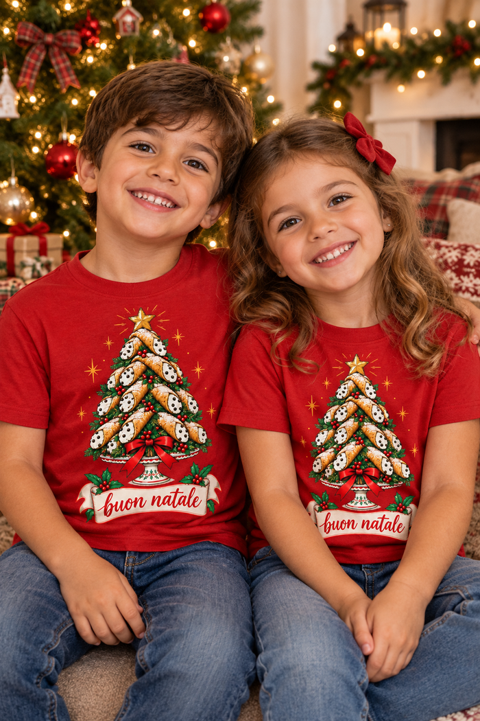 Two young Italian kids in Cannoli Tree Buon Natale shirts by the Christmas tree