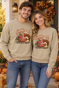 Young couple wearing matching Sand Gobblegool sweatshirts on a Thanksgiving porch